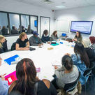 large group of diverse social workers having a meeting gathered around a table