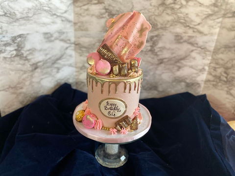 pink cake with gold drip and chocolates