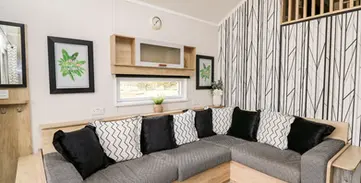 Cozy modern living room with grey L-shaped sofa and stylish cushions.