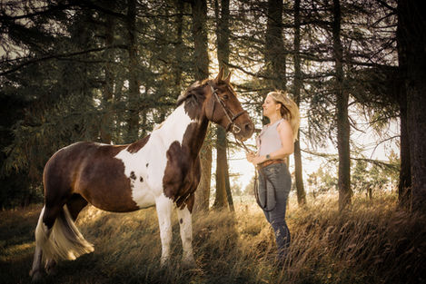 Woman and paint horse in woods