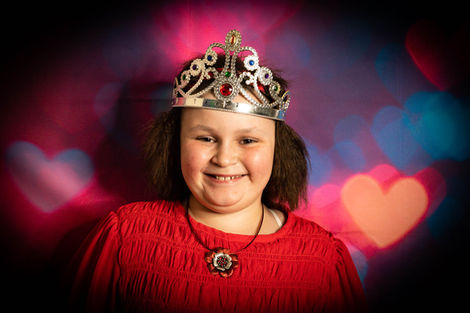 Smiling girl wearing a tiara and red top