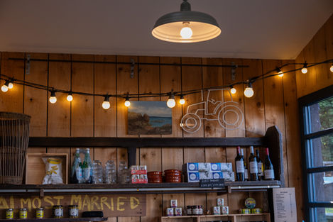 Rustic shop interior with string lights, tractor decoration, and shelves of goods