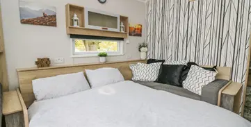 Cozy modern bedroom featuring a large bed and stylish patterned wall.