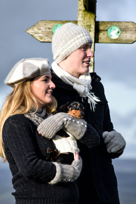 Couple holding small dog, winter walk