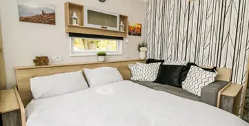 Stylish compact bedroom featuring a white bed, sofa, and modern striped wall.