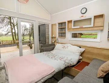 Sofa bed pulled out in modern living room with patio view.