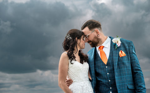 Happy wedding couple foreheads touching, stormy sky Photography