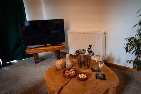 Relaxing living room with TV, snacks, and champagne