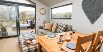 Bright modern living room with dining table and scenic deck view.