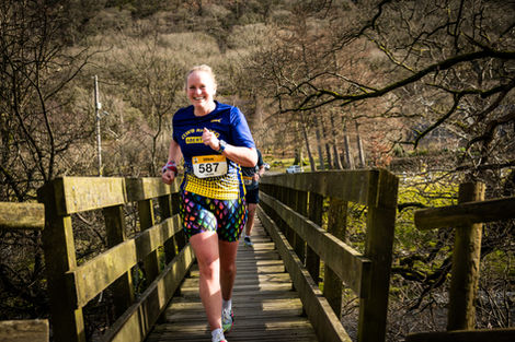 Smiling woman running race number 587