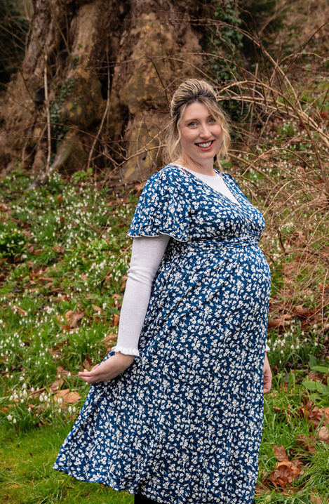 Pregnant woman in floral dress, spring flowers