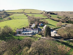 Aerial view of a countryside estate nestled in rolling green hills