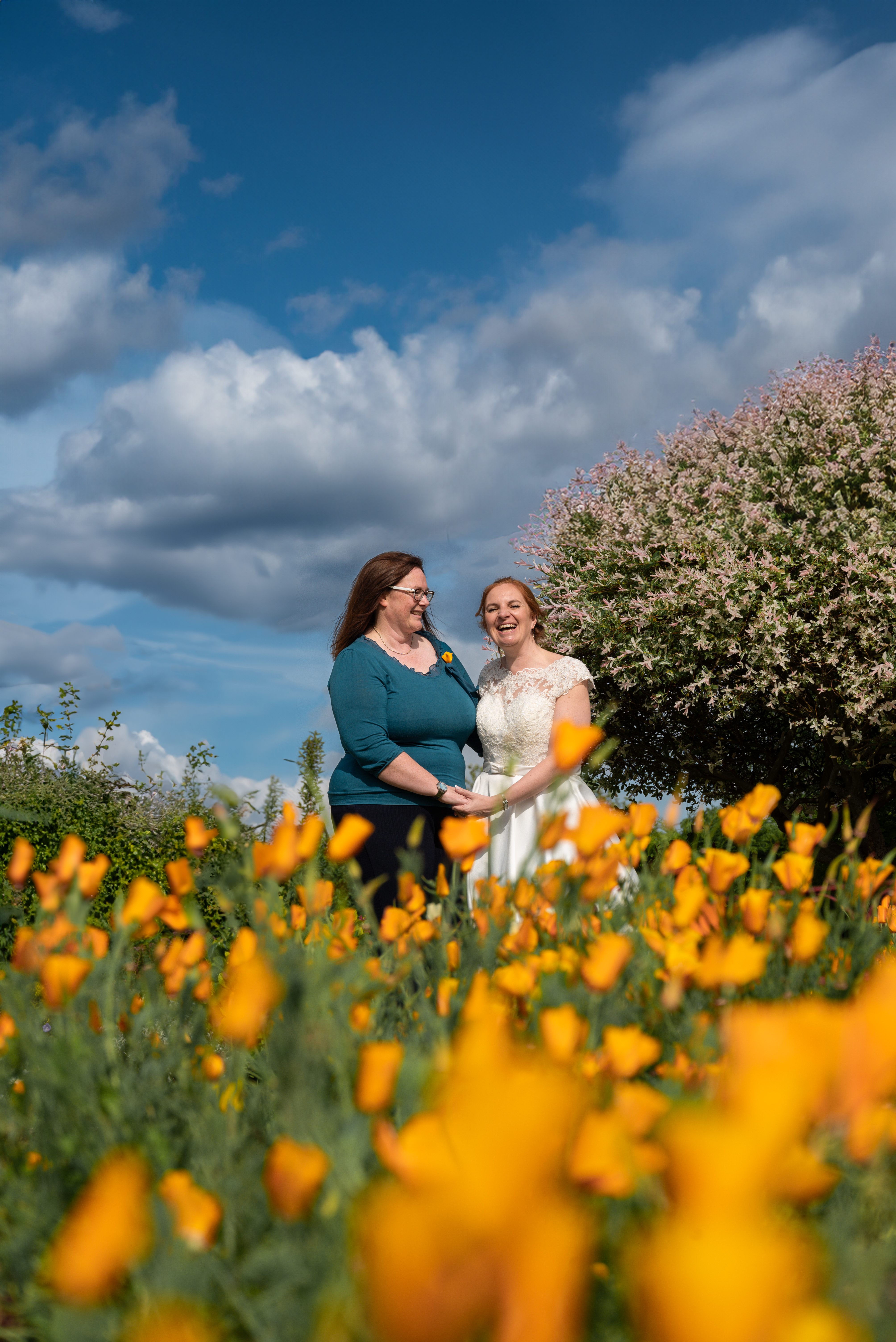 Happy Couple couple in wedding attire among orange flowers