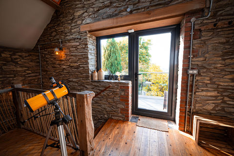 Telescope near stone wall, door to scenic view