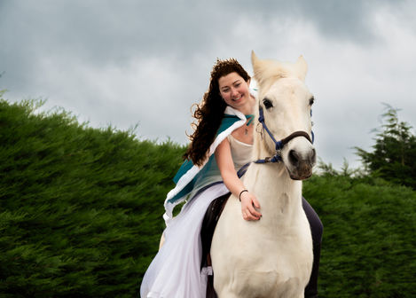 Smiling woman riding a white horse