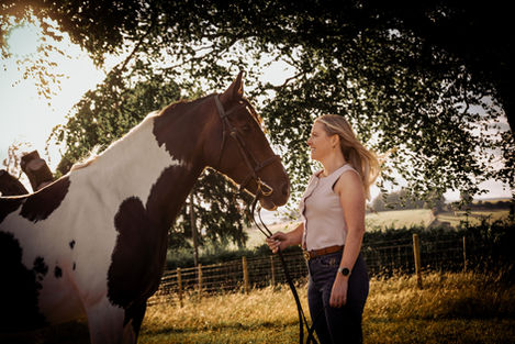 Woman and horse bonding at sunset