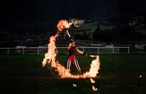 Fire performer twirling flames at night