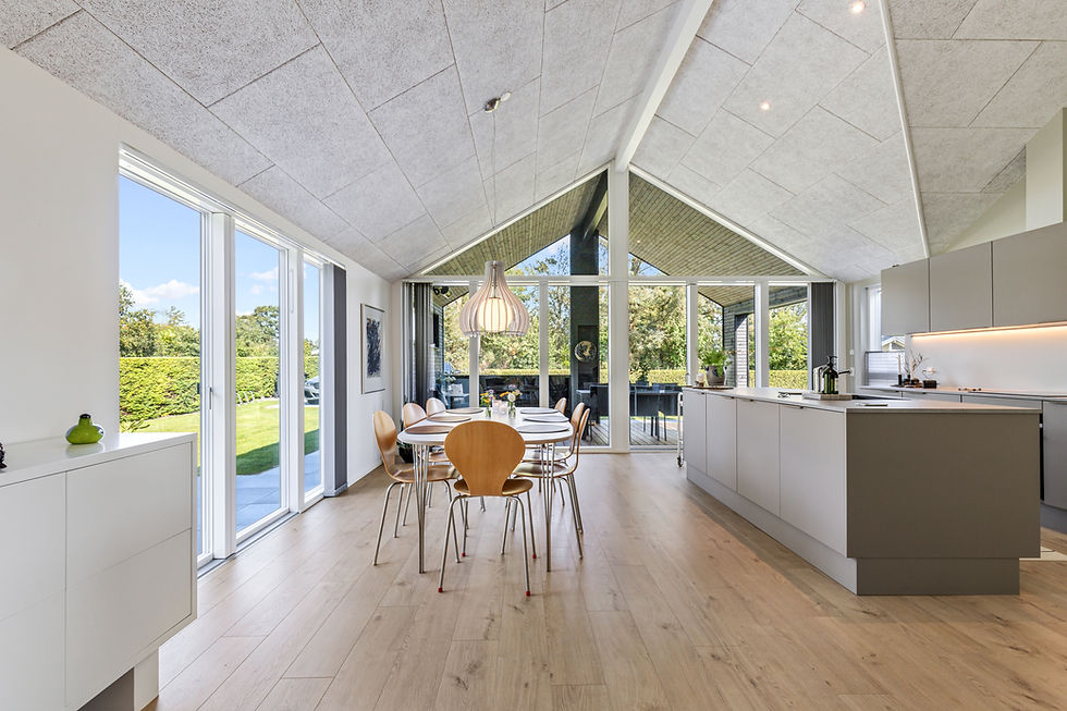 Hochwertige Immobilienfotografie einer modernen und luxuriösen Küche mit Essbereich, großen Glasfronten und hellem, eleganten