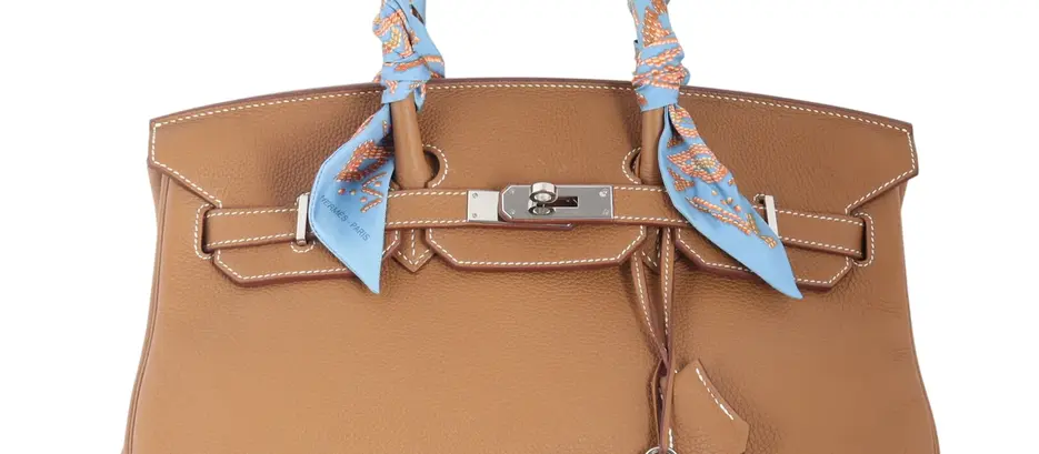 Brown leather handbag with blue patterned scarf-wrapped handles, silver clasp and padlock, on a white background; Hermès Paris text visible