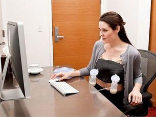 a woman pumps her breasts at a desk