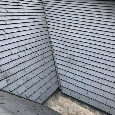 Close-up view of freshly installed grey slate roof tiles on a residential property exterior
