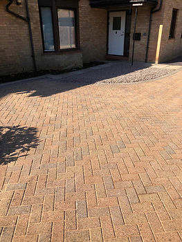 Close-up view of freshly relaid tan and orange block paving stones forming a neat pattern