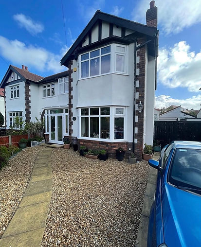 Semi detached house with black timber detailing and white rendered exterior
