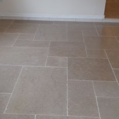 Light grey stone floor tiles laid in a modular, multi-size pattern
