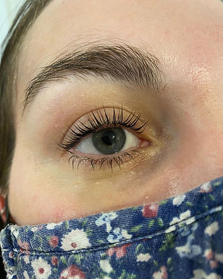 Close up of a perfectly shaped eyebrow and long lifted eyelashes on a salon client
