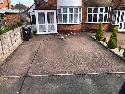 Block paved driveway leading to house front during rotary surface cleaning