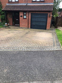 Cleaned grey block paving driveway showing neatly sanded joints between stones