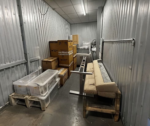 A narrow storage unit filled with stacked cardboard boxes