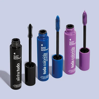 Three open mascara tubes with black, blue, and purple wands on light blue