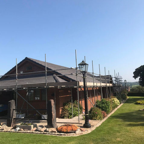 Large residential building completely surrounded by scaffolding for extensive exterior refurbishment