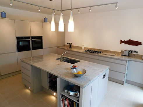 Modern kitchen with gray cabinets, central granite island, pendant lights, and wall decor