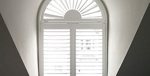 Bespoke shaped plantation shutter perfectly fitted into a unique arched window feature