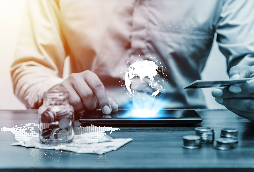 A businessman uses a tablet with a glowing digital globe hologram