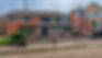 Construction workers laying block paving on a driveway in front of a brick house
