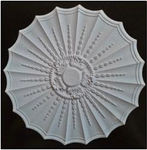 White ceiling medallion with intricate floral and scroll patterns