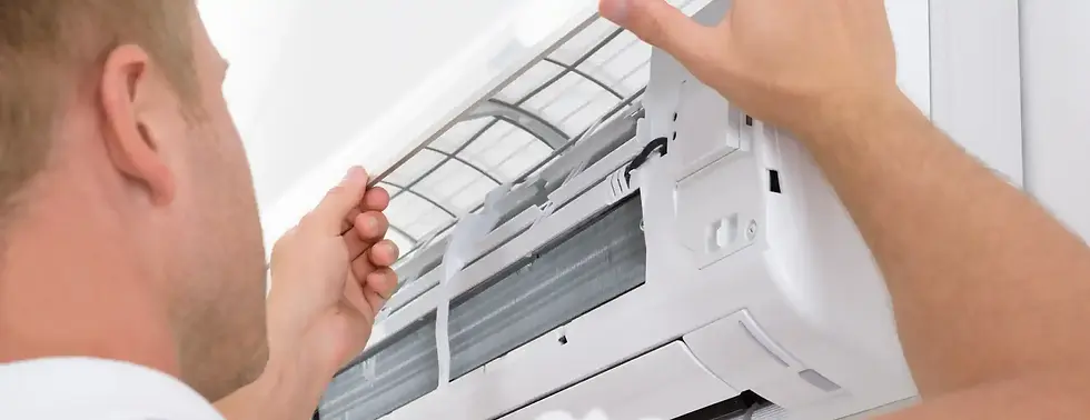 A person inspects and adjusts the filter of a wall-mounted air conditioning unit