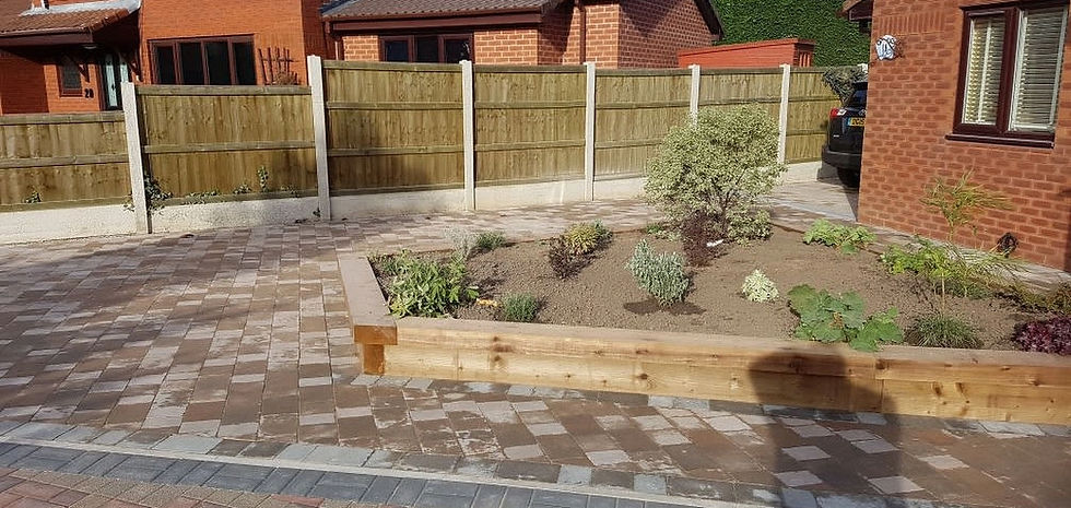 New block paved driveway with an integrated wooden raised planter and a close-board garden fence