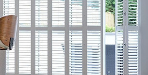 Large tracked plantation shutters gliding smoothly across a spacious patio door opening