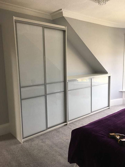 Sliding closet doors fitted under a sloped ceiling in a modern room