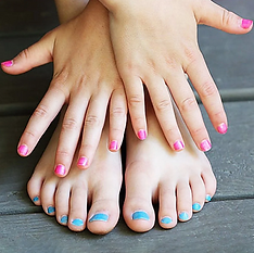 A close-up of a woman's feet showcasing blue and pink manicured nails on her toe