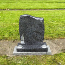 Curved grey granite headstone featuring an etched church window design