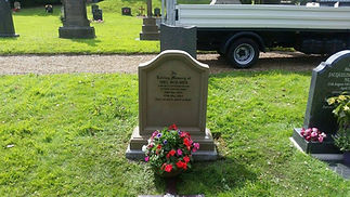 A gravestone in a cemetery with an inscription dedicated to Mel Holmes