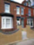 Red brick townhouse with white-framed windows and a bay window
