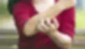 Person holding their forearm in discomfort representing allergy and inflammation symptoms