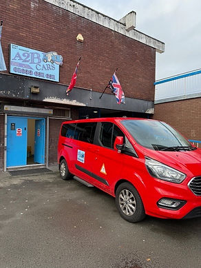 A red van parked in front of a building, showcasing its vibrant color against the neutral backdrop