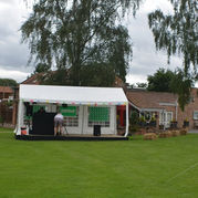 White event marquee tent set up on a spacious green lawn